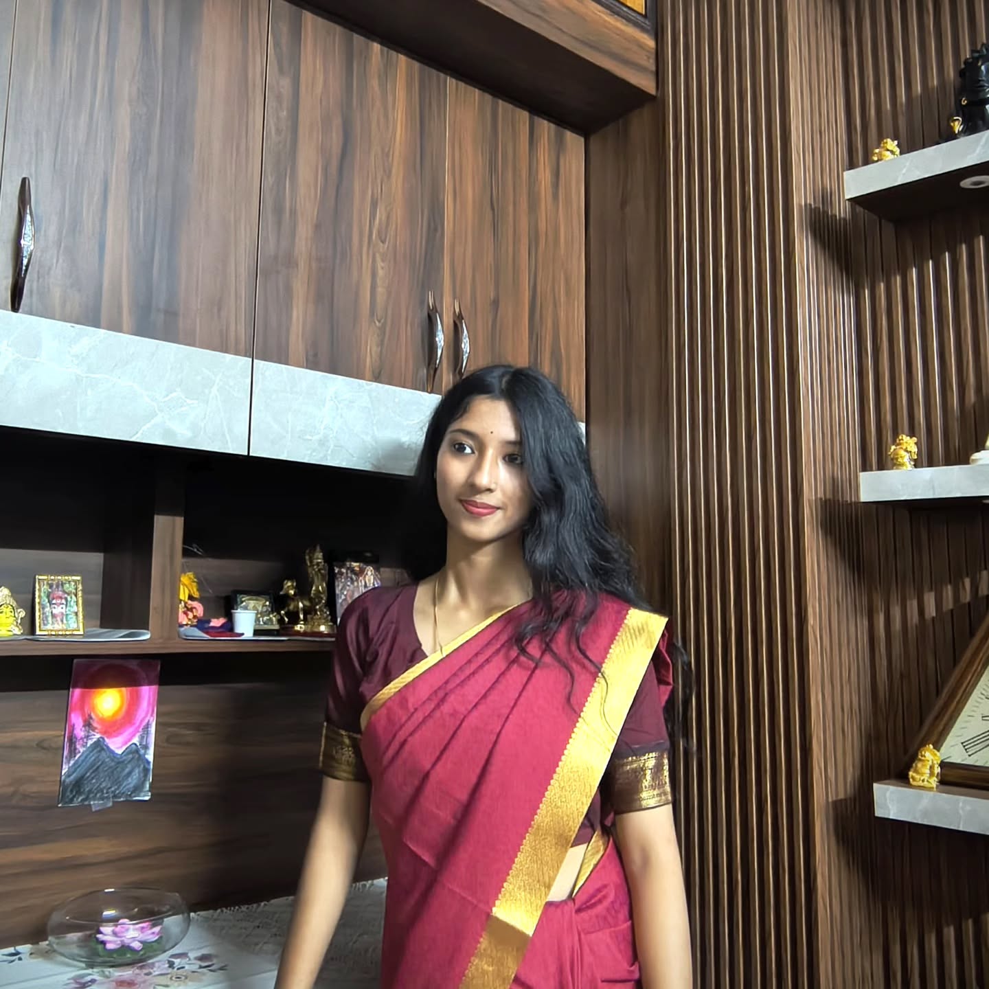 Snigdha Chakraborty in a colour portrait beside artwork